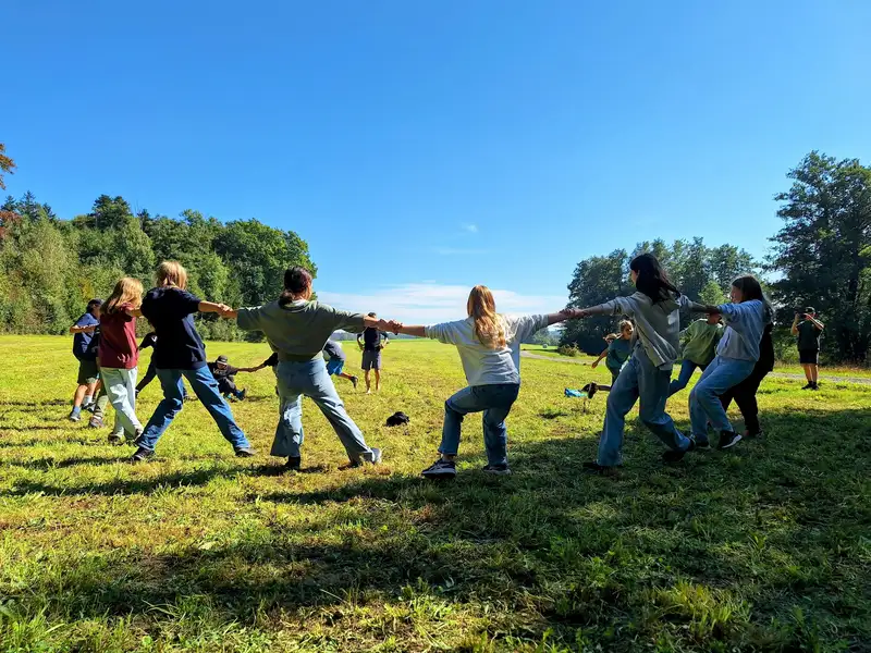 Children playing tug-of-war in a grassy field